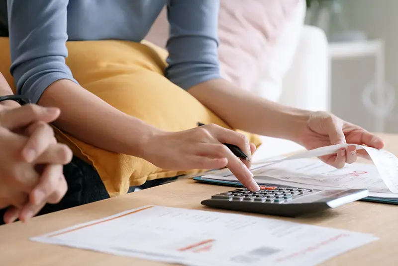 person using calculator while holding a receipt