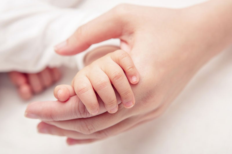 mom holding newborn babie's hand