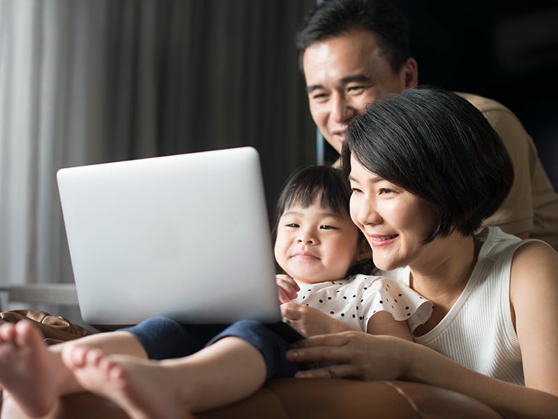 family of three using laptop.